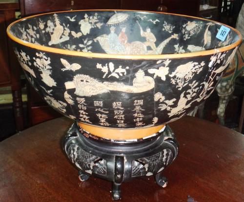 A black glaze Oriental bowl, decorated with animals and figures and an associated stand.