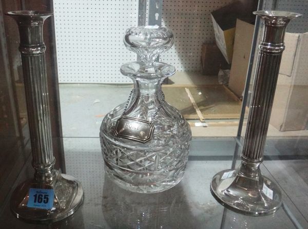 A pair of silver plated fluted candlesticks and a cut glass decanter with a silver 'Port' label.