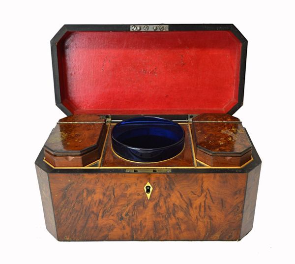 A George III burr yew tea caddy of canted rectangular form, with twin lidded interior centred by a mixing bowl, 29cm wide.  Illustrated