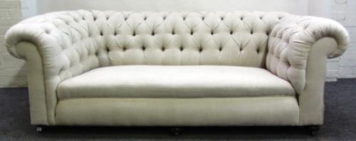 A cream upholstered button back drop end sofa on bun feet, 208cm wide.