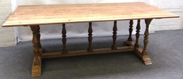 A 19th century pine refectory table, the rectangular plank top on nine baluster turned supports and stepped block feet, 103cm x 225cm.