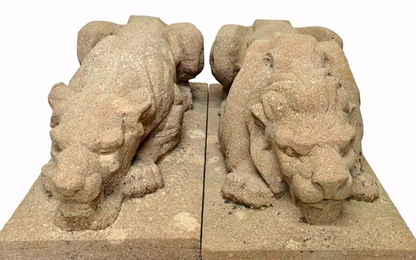 A pair of 20th century carved stone figures of a lion and lioness in recumbant pose, on rectangular bases, signed 'R. Demange', 112cm wide x 49cm deep