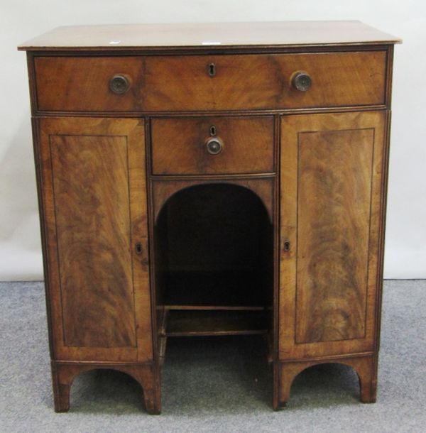 A George III mahogany bow front knee hole side cupboard, with two drawers and pair of cupboards, on bracket feet, 69cm wide.