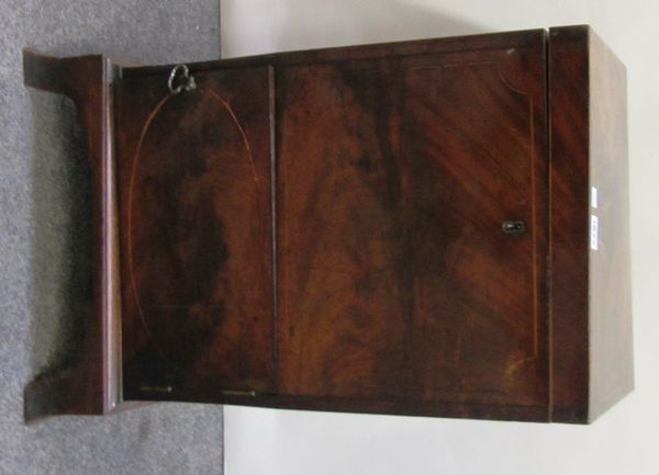 A George III inlaid mahogany cellarette, the rectangular lift top revealing a six bottle division interior over single cupboard, on splayed bracket fe