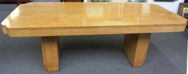 An Art Deco satin birch dining table, the rectangular top with re-entrant corners, on a pair of slab trestle standards, 97cm wide x 213cm long.