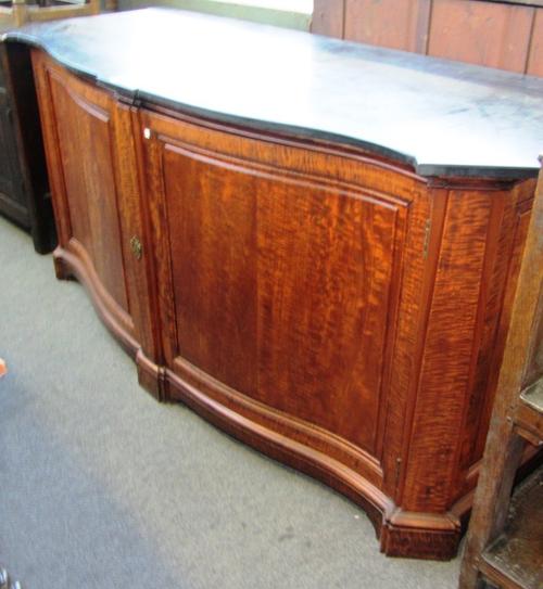 A large 19th century side cabinet, the serpentine slate top with outstepped corners, over a sycamore two door base resting on a plinth, 201cm wide.