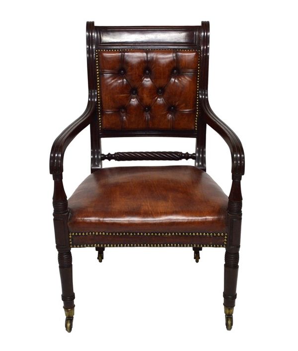 A Regency mahogany framed open arm library chair, with later brown studded leather upholstery, on turned supports.  Illustrated