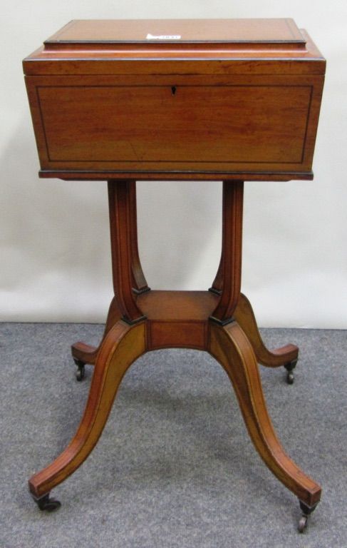 An early 19th century ebony banded satinwood teapoy, on four open columns and four downswept supports, 42cm wide.