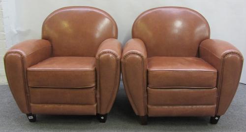 A pair of 20th century Art Deco style faux brown leather upholstered club easy armchairs, on tapering square ebonised supports.