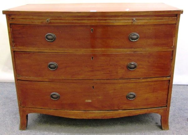 A Regency mahogany bow front chest, with brushing slide over three long graduated drawers, on splayed bracket feet, 101cm wide.