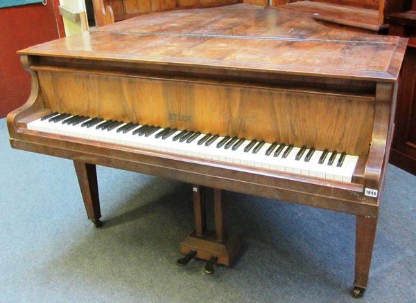 A walnut cased iron framed overstrung baby grand piano by Steck, on tapering square supports, stamped 120457, with Harrods retail plaque, 131cm deep x