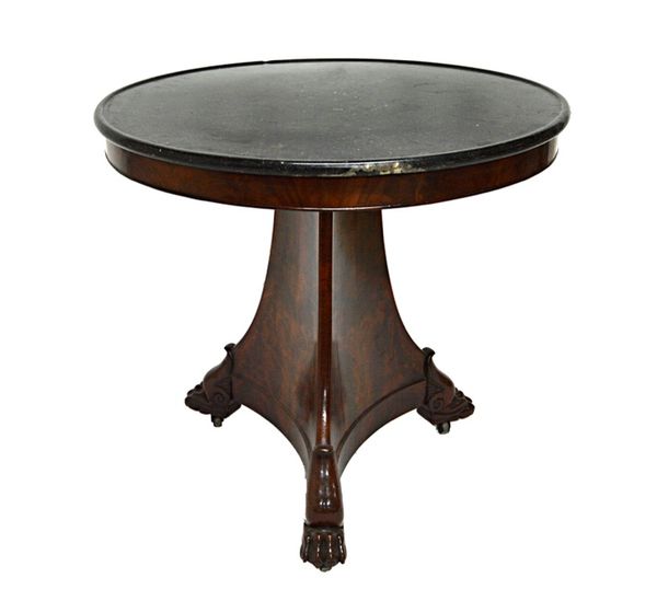 A French Empire gueridon, the circular dished marble top on a flared mahogany concave sided triangular base and three paw feet, 81cm wide.   Illustrat