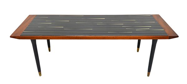 A mid 20th century teak framed rectangular coffee table with glass inset top, on tapering turned ebonised supports and gilt metal caps, 129cm x 46cm.