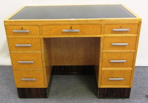 A 20th century satin birch and birds eye maple writing desk with nine drawers about the knee, on a coromandel plinth base, 106cm wide.