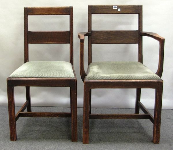 A set of six oak framed Arts & Crafts square back dining chairs on canted square supports, each with a numerical stamp to the underside, to include on