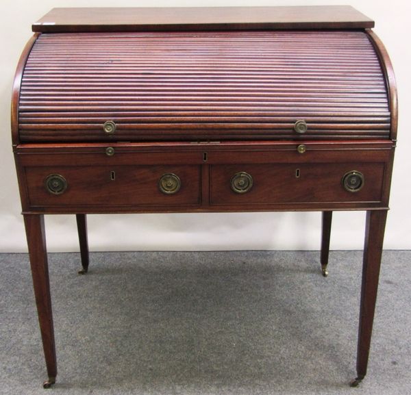 A George III mahogany writing desk, the retractable tambour top revealing a fitted pull-out interior over two frieze drawers, on tapering square suppo