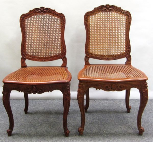 A set of ten Louis XV style stained beech dining chairs, with carved crest over cane back and serpentine seat, on carved cabriole supports (four of th