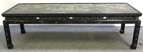 An early 20th century Chinese mother of pearl inlaid black lacquer rectangular low table on block supports, 152cm wide.