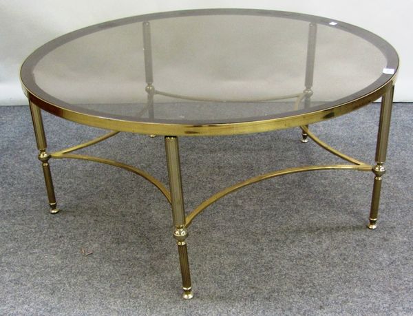 A 20th century lacquered brass and glass circular coffee table, on reeded supports united by concave stretchers, 92cm wide.