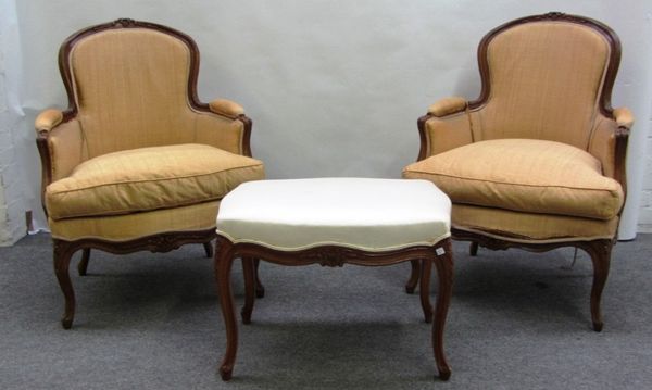 A pair of Louis XV style stained beech fauteuils, each with floral carved crest and serpentine seat, on cabriole supports, together with a similar foo