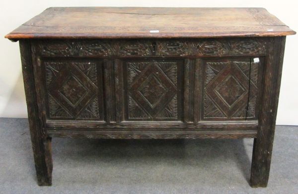 A 17th century oak coffer, with triple carved front panel on tall stile feet, 106cm wide