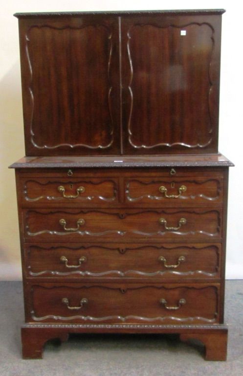 A George II style mahogany estate cabinet, 19th century, the pair of shaped panel doors enclosing a pigeon hole interior, over brushing slide and two