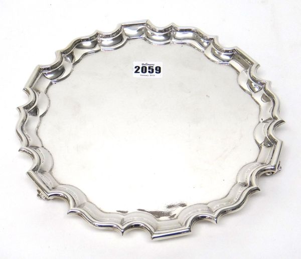 A silver salver, of shaped circular form, in the Chippendale style, raised on three scroll feet, diameter 26cm, London 1919, weight 579 gms.