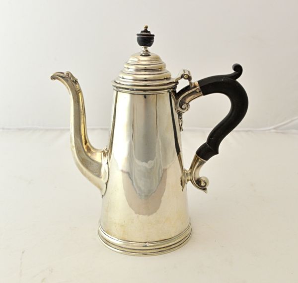 A silver coffee pot, of tapering cylindrical form, with a faceted spout, on a circular foot and having black fittings, Sheffield 1918, gross weight 51