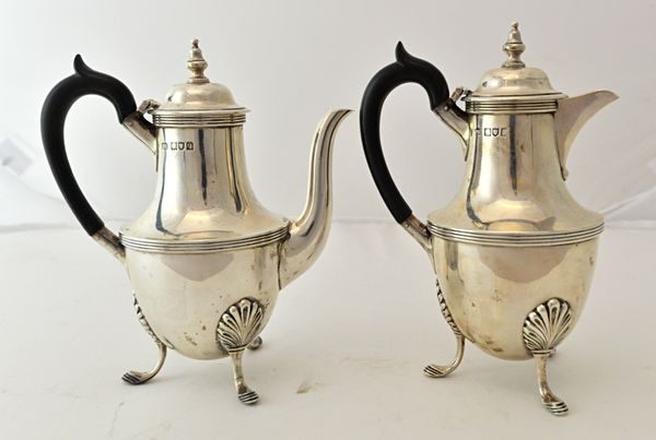 A silver two piece cafe au lait set, comprising; a coffee pot and a hot milk jug, each piece of urn shaped form, decorated with reeded bands and raise