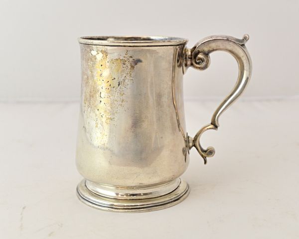 A George II silver mug, of baluster form, having a scrolling handle, Newcastle 1740, weight 363 gms.  Illustrated