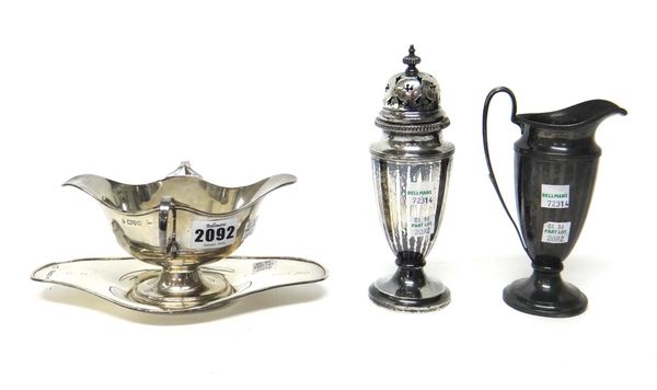 Silver, comprising; a twin handled sauceboat, with a matching sauceboat stand, Chester 1906, a sugar caster and a matching cream jug, each with panel