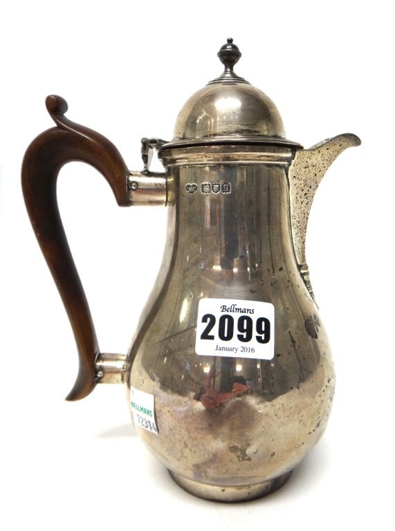 A silver hot water jug, of baluster form, in the 18th century taste, with a wooden handle, London 1911, gross weight 549 gms.