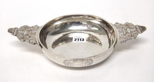 A French provincial silver ecuelle, the bowl of circular form, engraved Claude Cornau within a rococo cartouche, the cast handles decorated with male