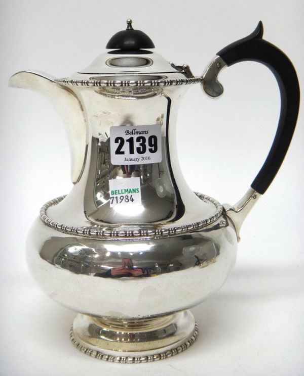 A silver hot water jug, of baluster form, decorated with beaded rims and on a circular foot, Sheffield 1927, gross weight 552 gms.