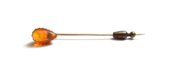 A gold and fire opal set single stone stick pin, mounted with a pear shaped fire opal.