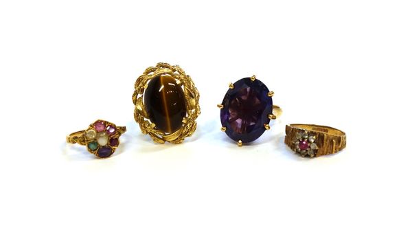 A gold ring, claw set with an oval cut synthetic corundum imitating alexandrite, detailed 18 CT, a gold ring mounted with an oval tiger's eye, detaile