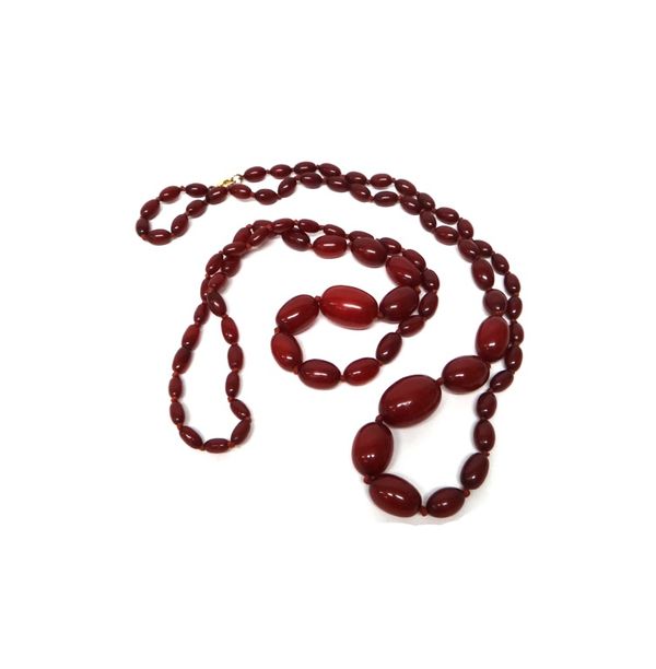 Two single row necklaces of reconstituted and treated graduated oval cherry coloured amber beads.