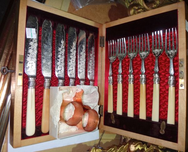 A cased set of silver plated knives and forks and three copper and silver napkin rings.