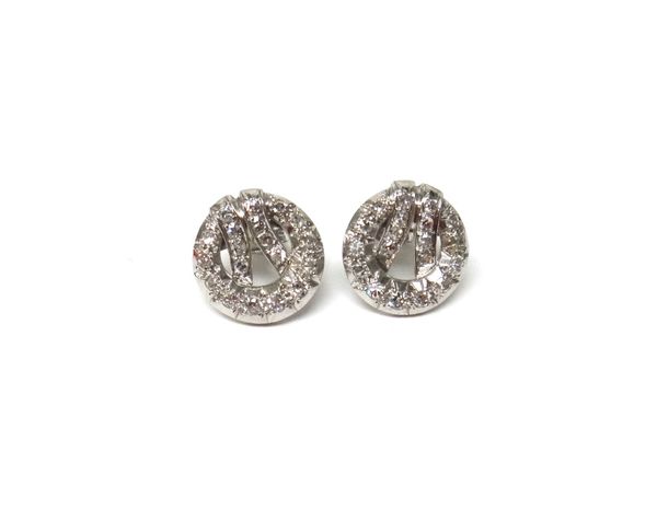 A pair of white gold and diamond set earstuds, each in a circular openwork design with a twin curved bar motif, mounted with circular cut diamonds, th