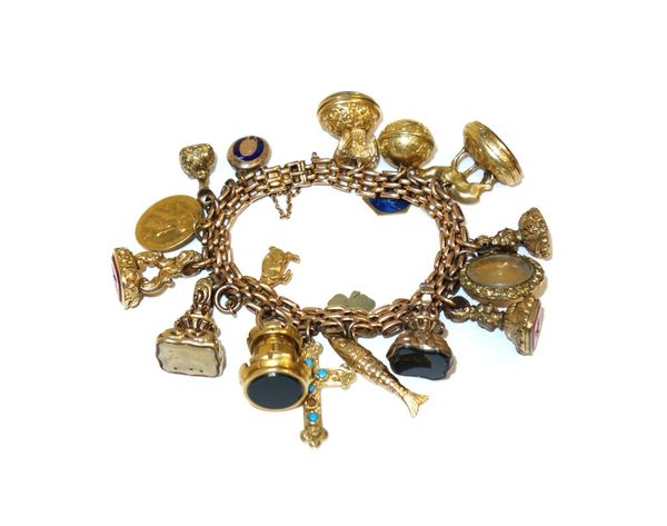 A gold multiple row oval link bracelet, on a snap clasp, detailed 15, fitted with a variety of pendant fob seals and charms, including; a bloodstone s