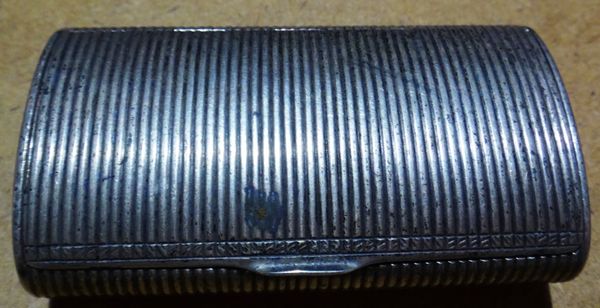 A European silver hinged lidded snuff box, of oval cylindrical form with reeded decoration.