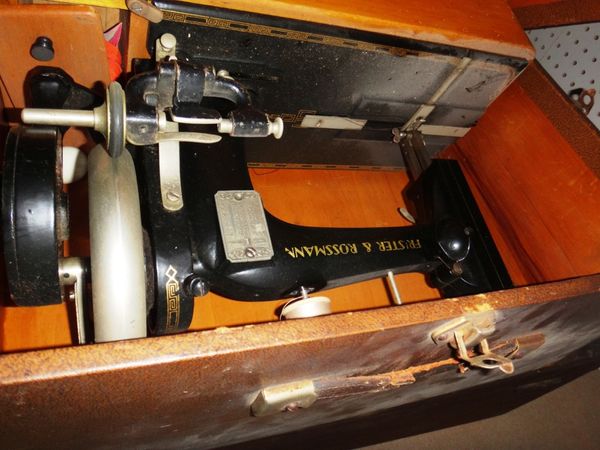 An early 20th century sewing machine and a wooden storage box.