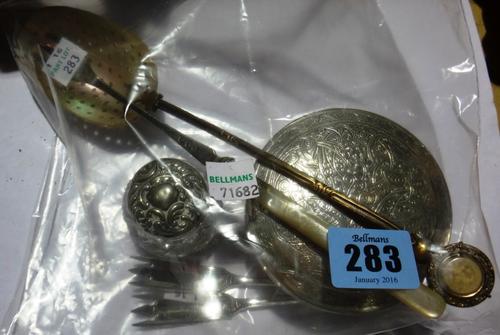 An Egyptian circular box and cover, having engraved decoration, a silver lidded faceted glass small toilet jar, Birmingham 1900, a brass handled spoon