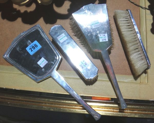 A lady's silver four piece dressing set, in Art Deco design, comprising; a hand mirror, two clothes brushes and a hairbrush, each piece with engine tu