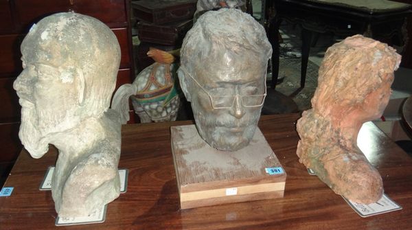 A bronzed resin head of a man with glasses, a stone bust, and a terracotta bust of a girl.