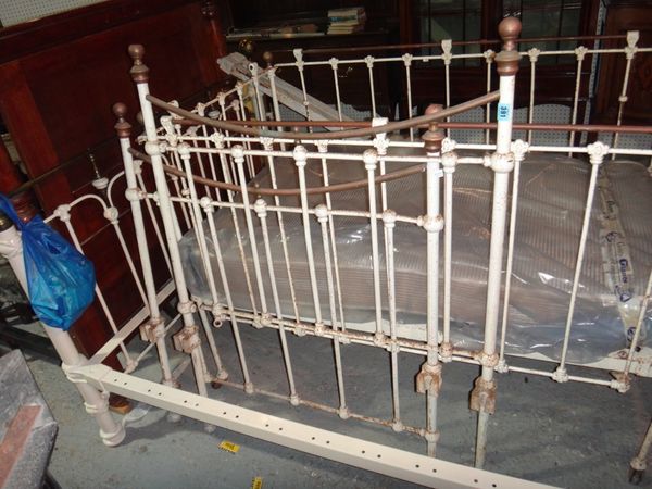 A wrought iron white painted single bed.