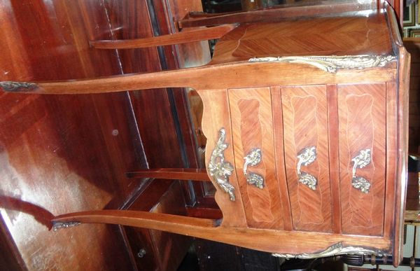 A 20th century walnut serpentine three drawer bedside chest.