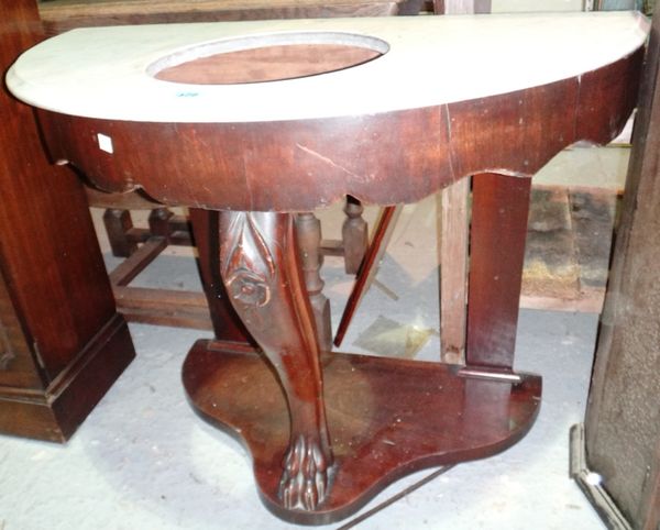 A Victorian mahogany washstand with a white marble top and washbowl.