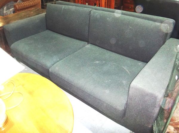 A 20th century black upholstered three seat sofa.