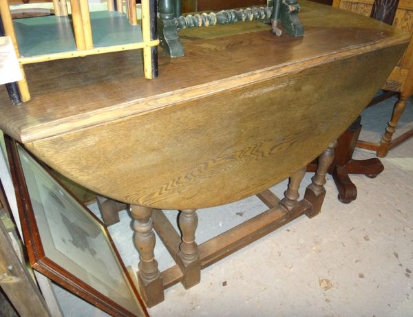 A 17th century style oak oval drop flap dining table.